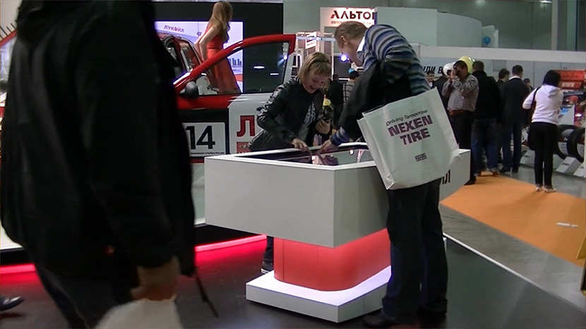 Visitors of the stand at the interactive touch table.